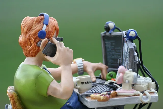 Figurine of a developer wearing headphones, sitting at his computer.